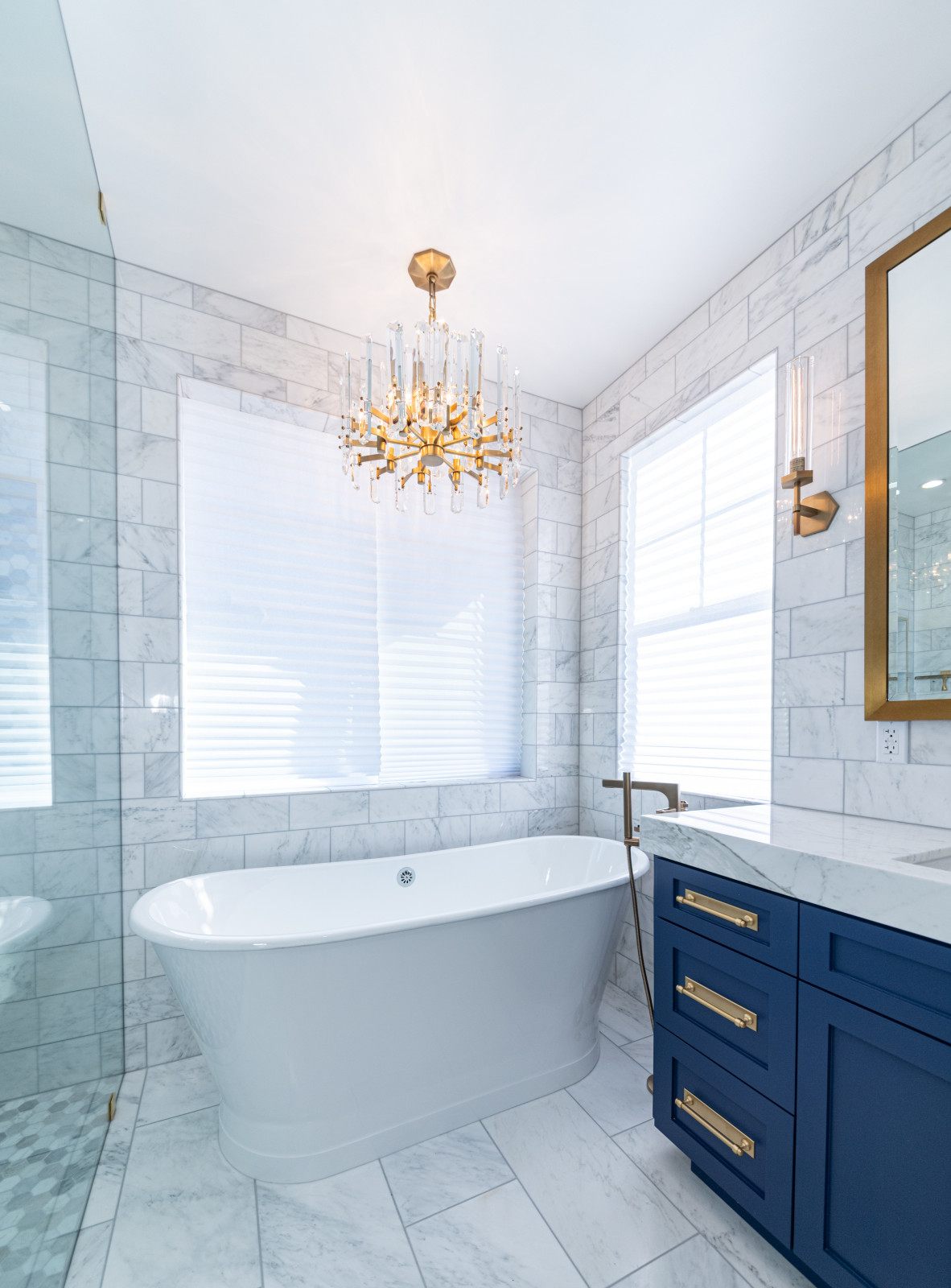 Calabasas master bathroom — freestanding tub, chandelier and navy vanity