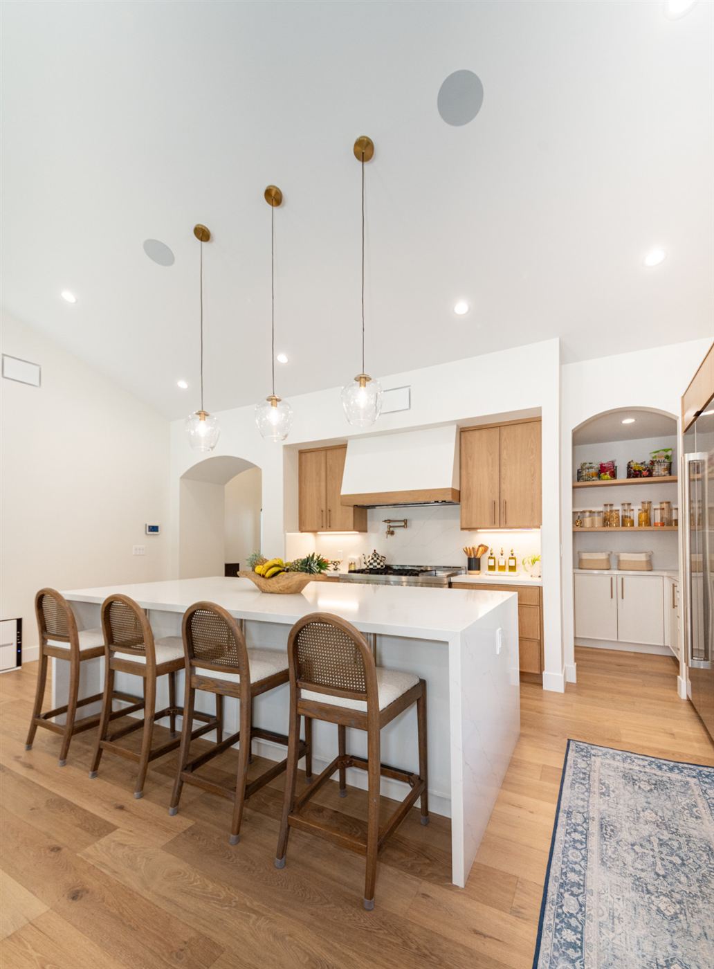White waterfall island with cane-webbing counter stools
