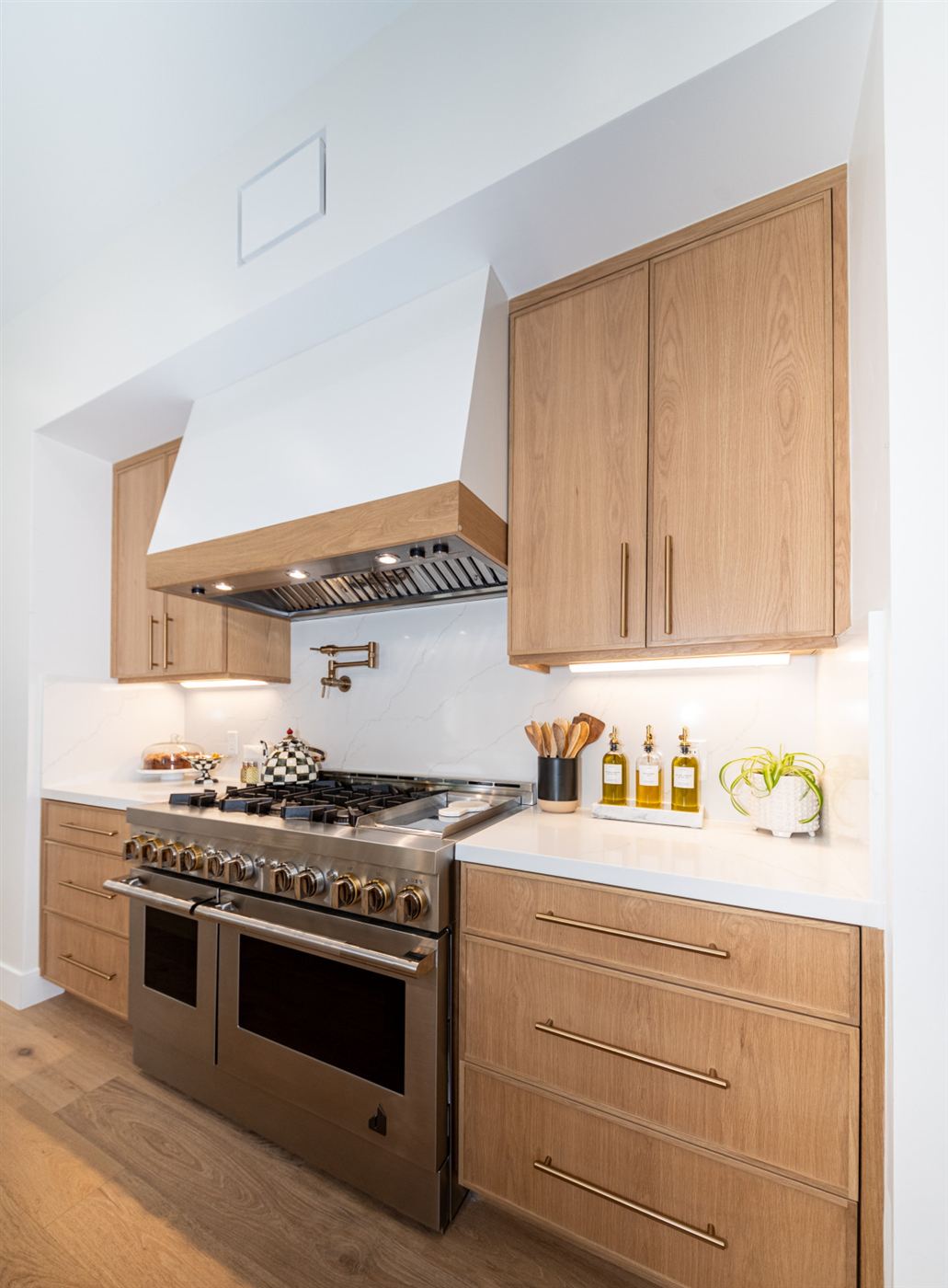 Kitchen with brass pot filler and professional stainless range