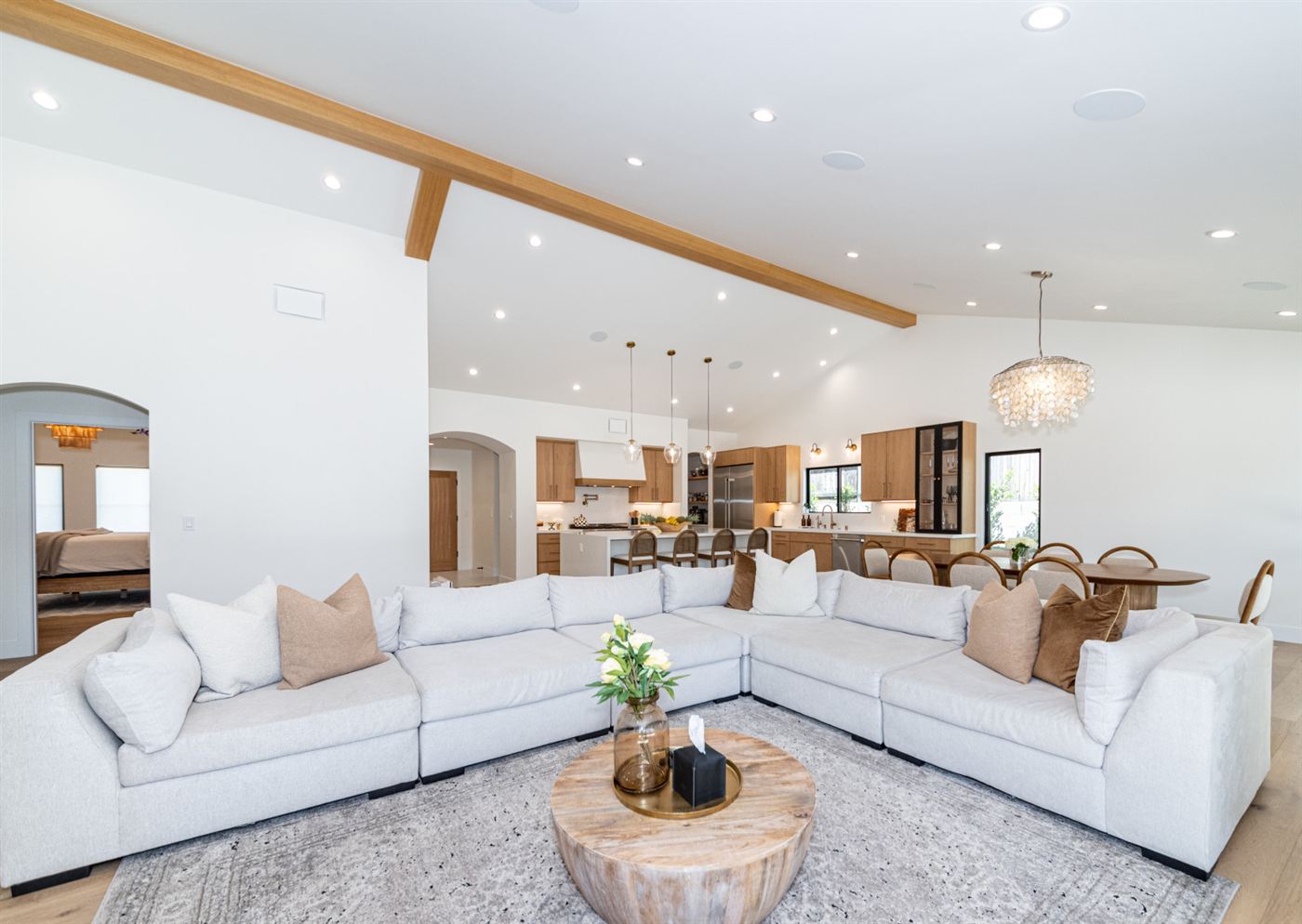 Open living space with neutral sectional and vaulted ceilings