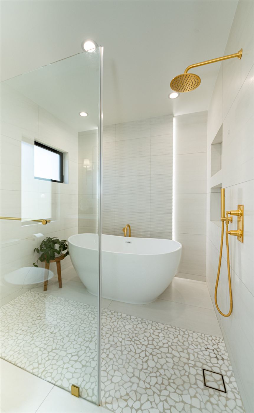 Bright bathroom with freestanding tub and brushed gold fixtures