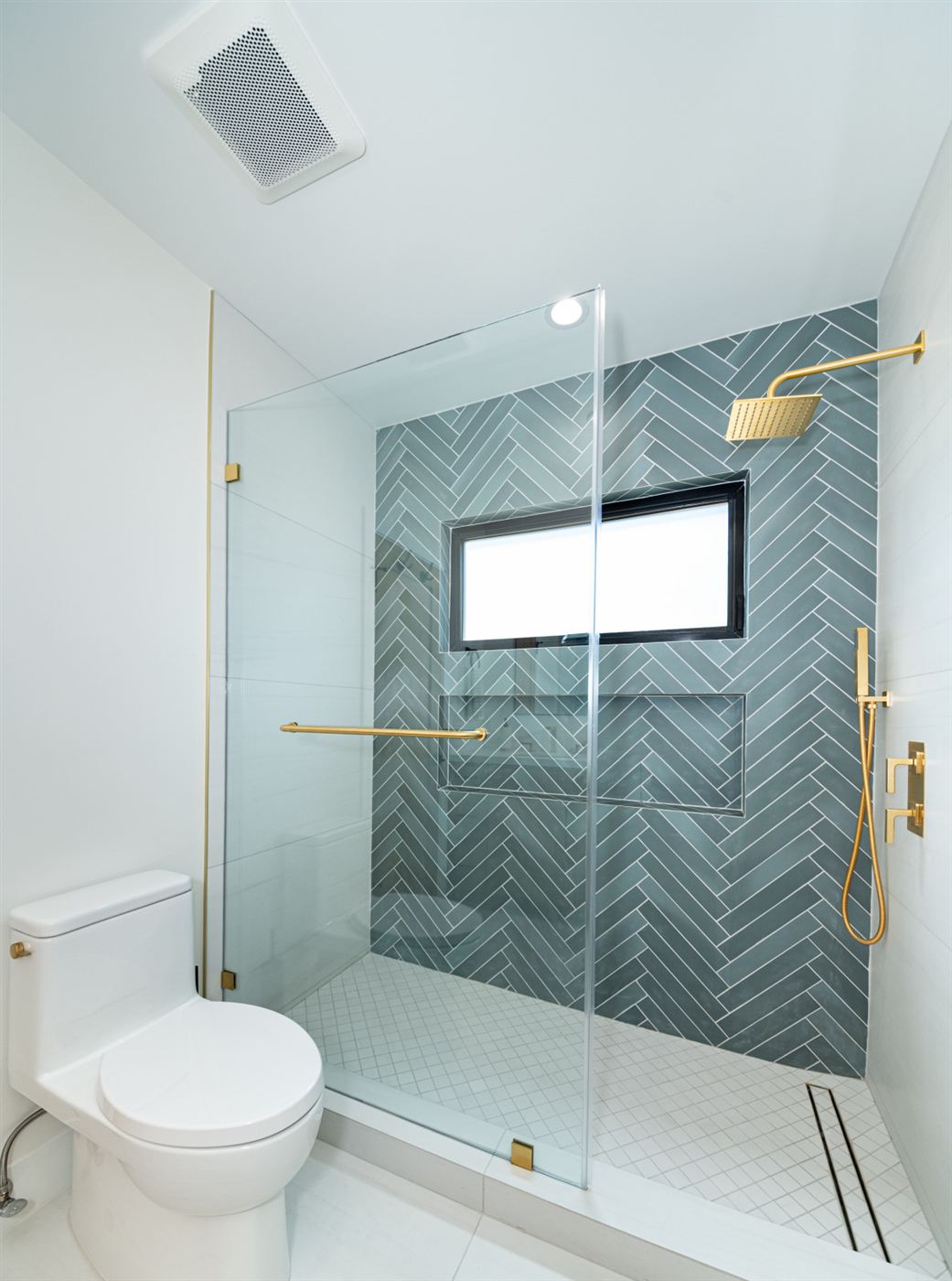 Bathroom with blue-gray herringbone tile accent wall