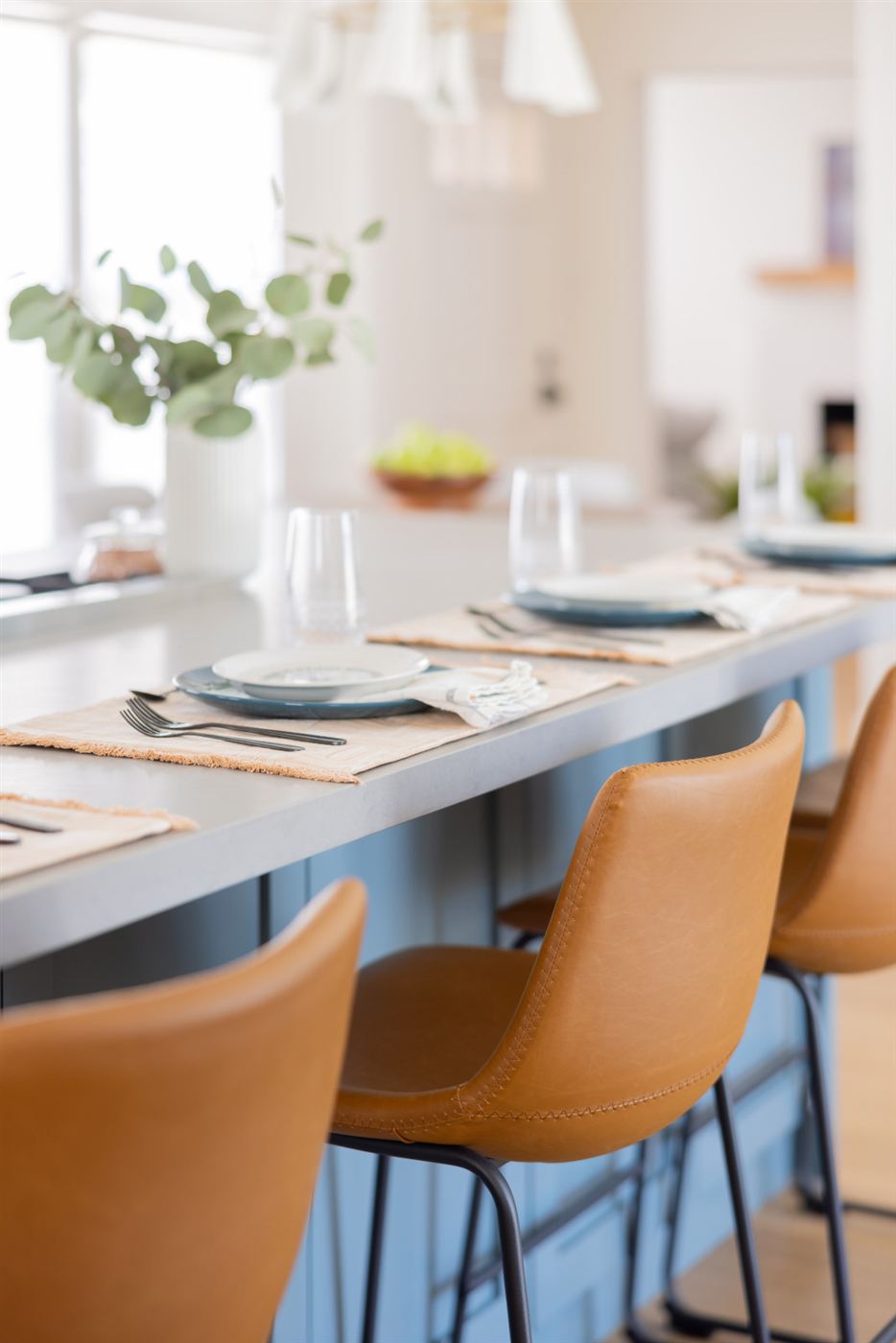 Kitchen island with soft blue cabinetry and light grey quartz countertop