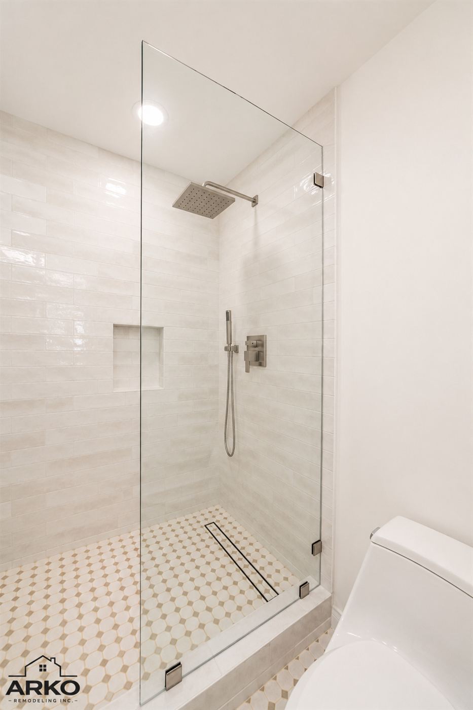 Frameless glass shower with rain head and tile niche